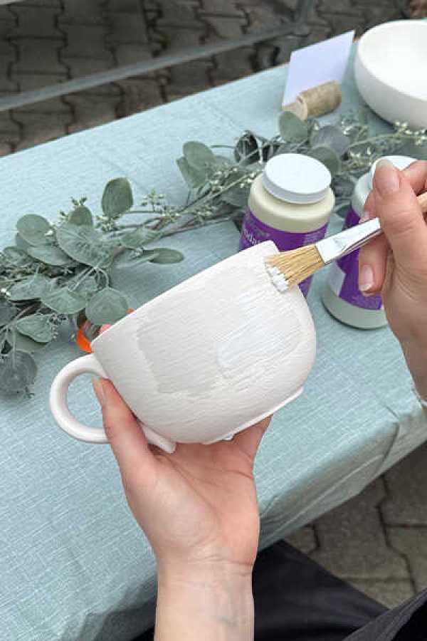 Keramik bemalen zwischen Pflanzen